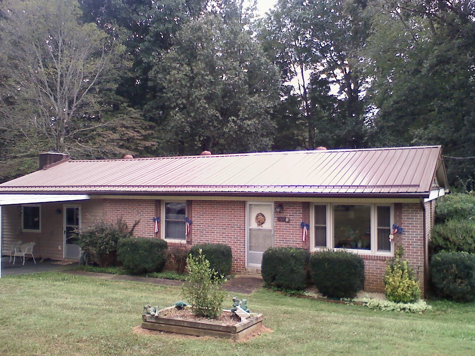 Bronze metal roof on a brick ranch home with a carport in Solana Beach